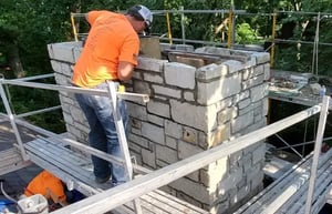 Renaissance restoration specialists working on the chimney of a historic building