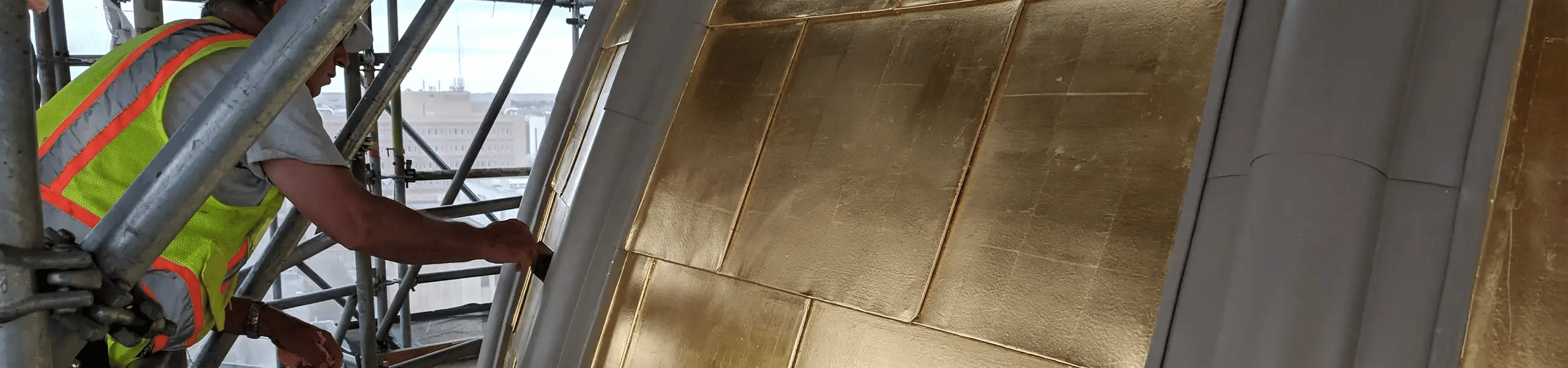 renaissance restoration worker repairing copper ornamentation on roof of historic building