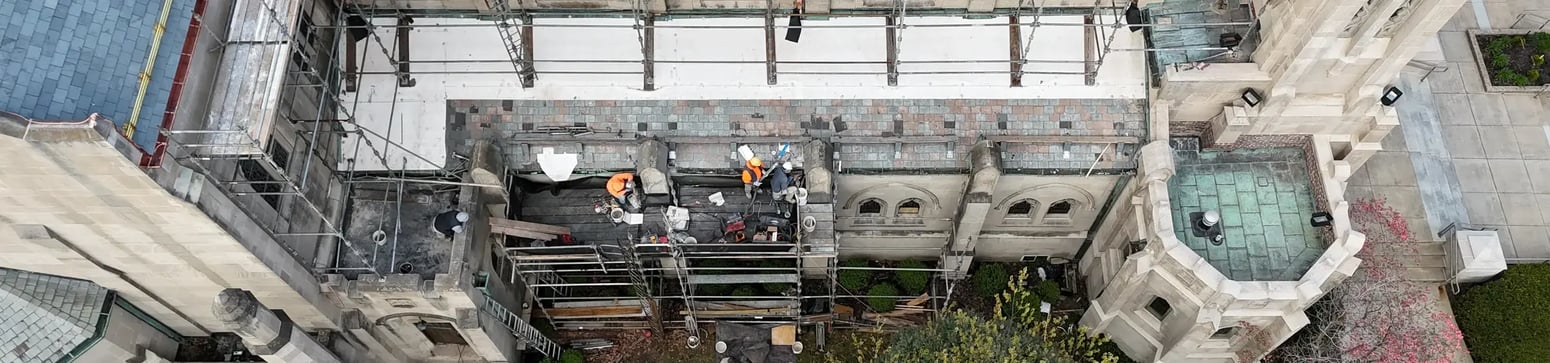 renaissance workers restoring a slate tile roof on a church