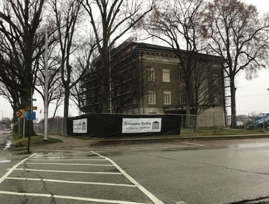 two story historic building with a construction safety fence around it