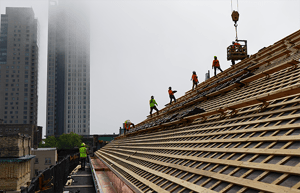 Workers on a historic commercial roof