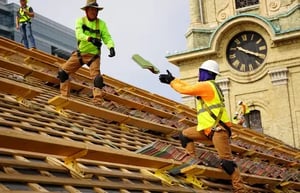 Renaissance restoration specialists secured on a roof