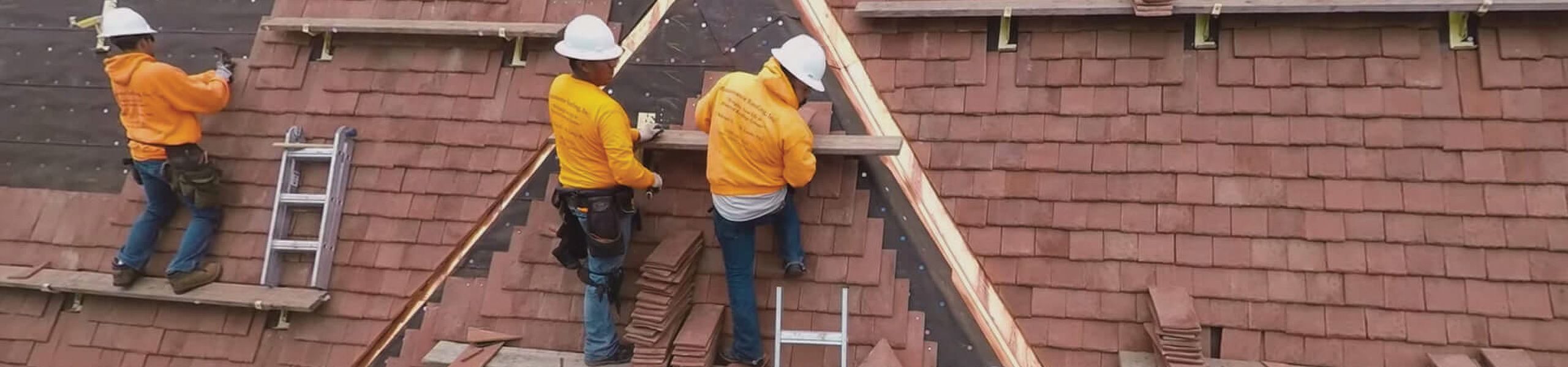 workers on a shingle roof