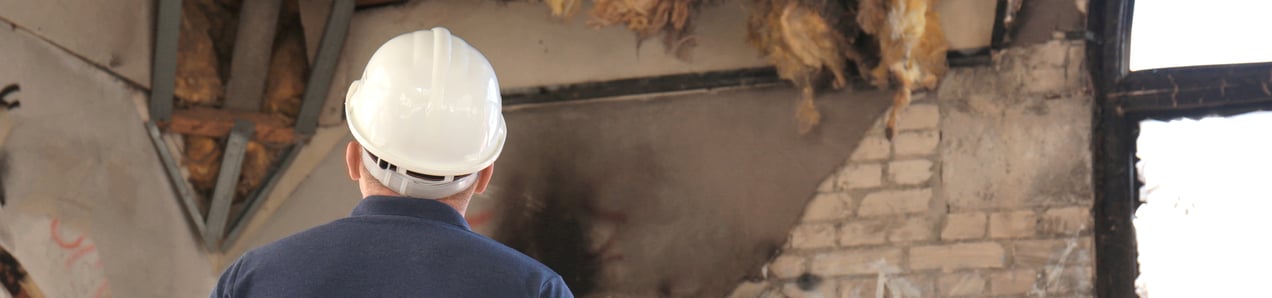 man assessing the damage on the inside of a historic home